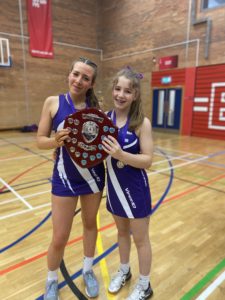 grace and dacota holding the netball trophy