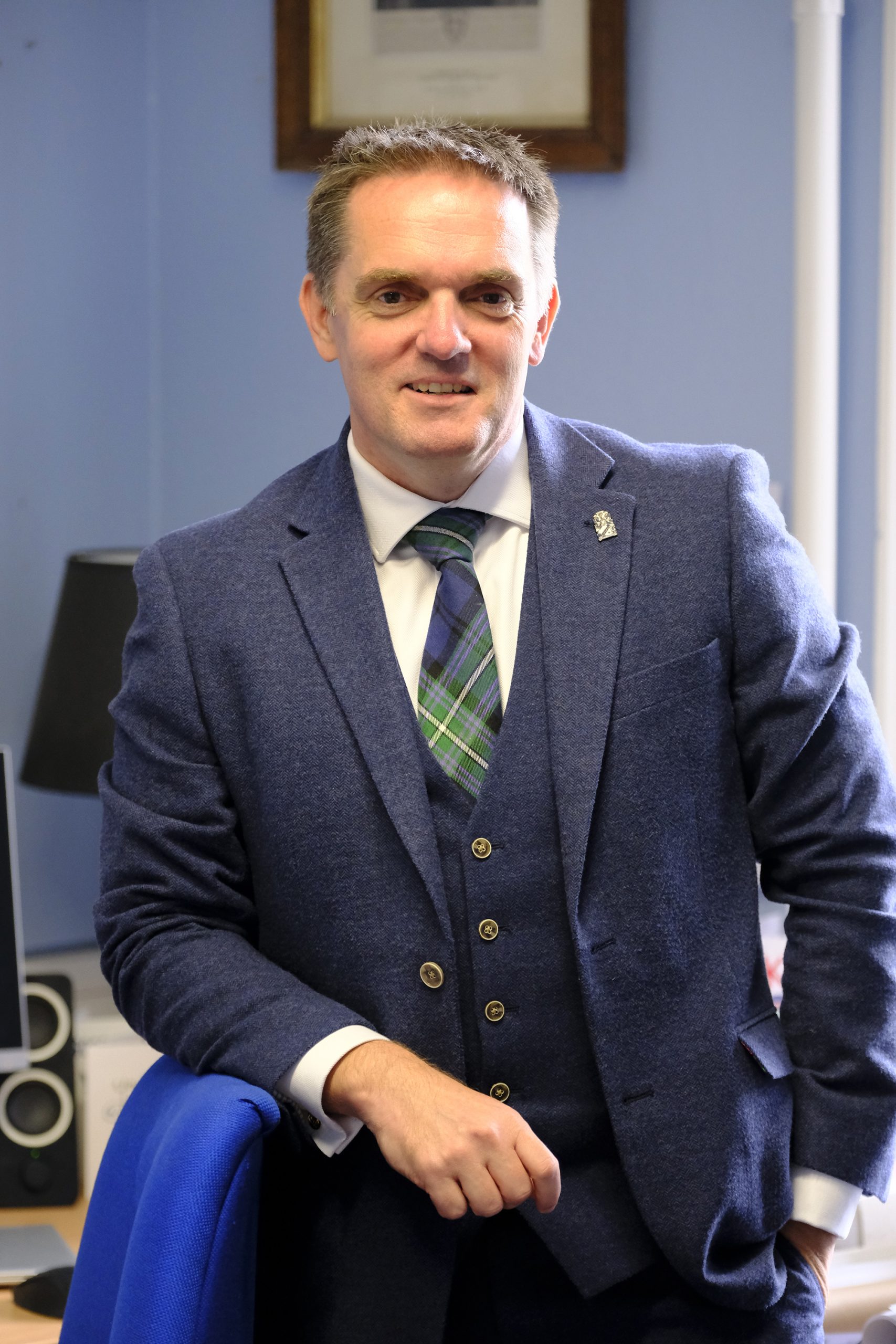 A man leaning on a chair smiling