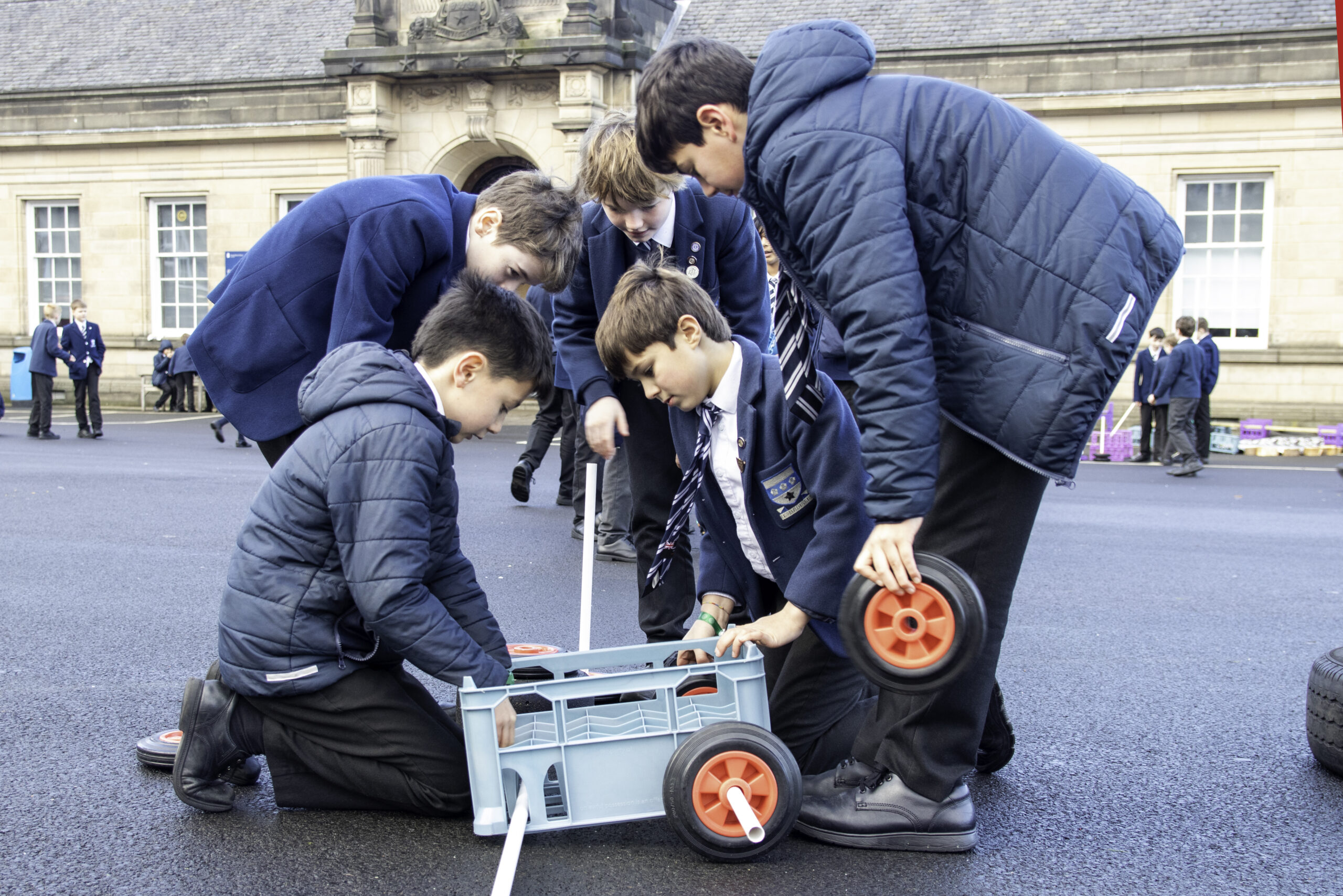 Pupils using the new loose parts equipment in the playground: creativity, problem solving and collaboration skills in action.